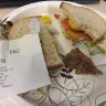 Wawa - tuna sandwich on rye with some type of paper in sandwich